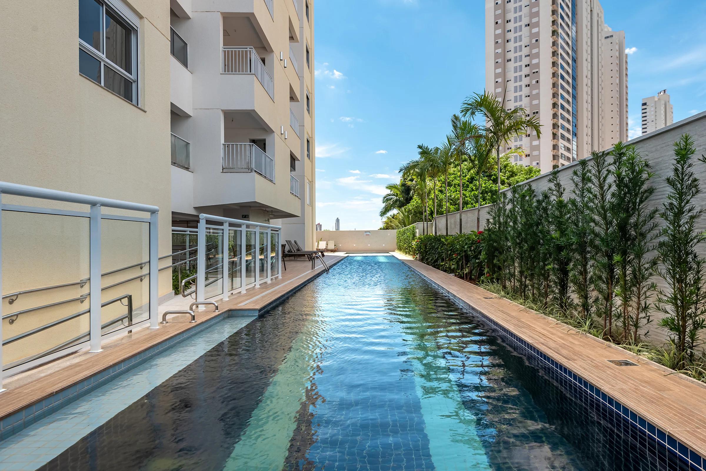 Piscina com raia de 25 metros e deck de madeira lateral
