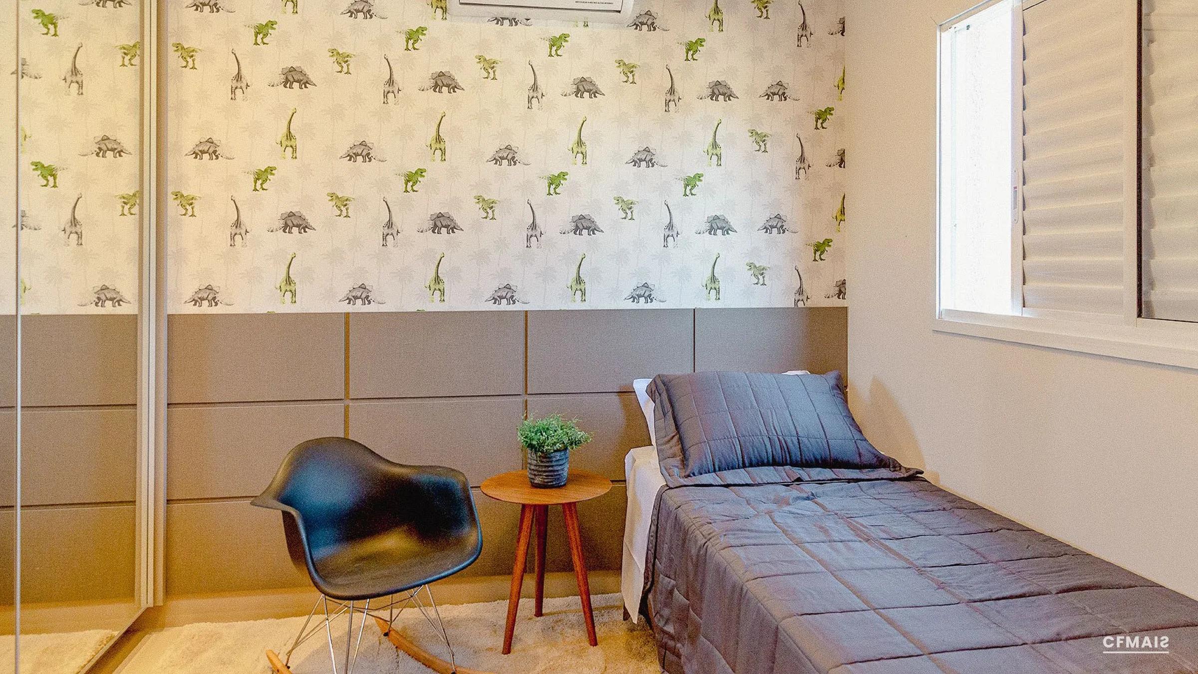 Quarto de solteiro decorado com cama, poltrona de apoio e papel de parede temático