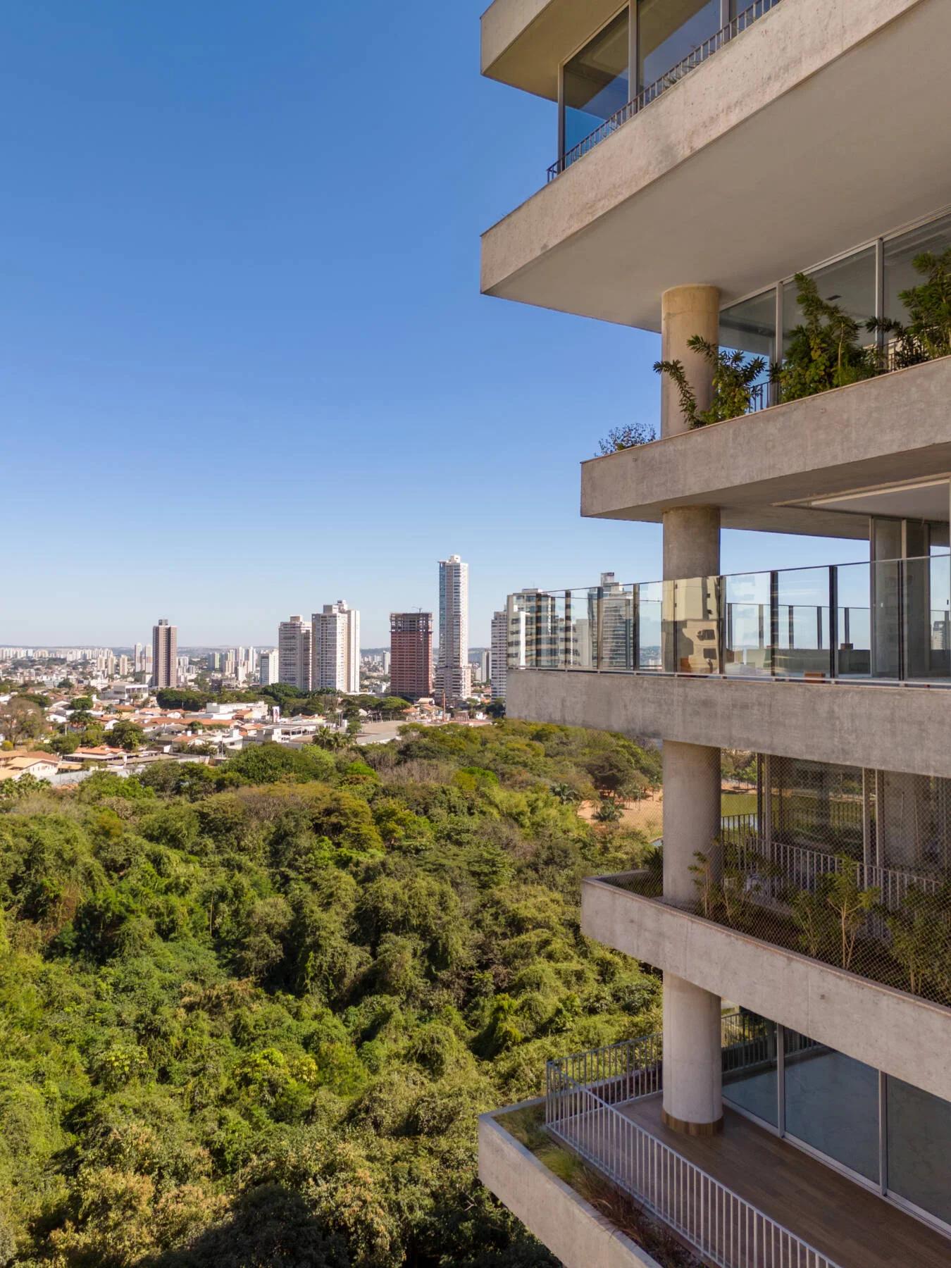 Foto da fachada do edifício com varandas e vista para a área verde