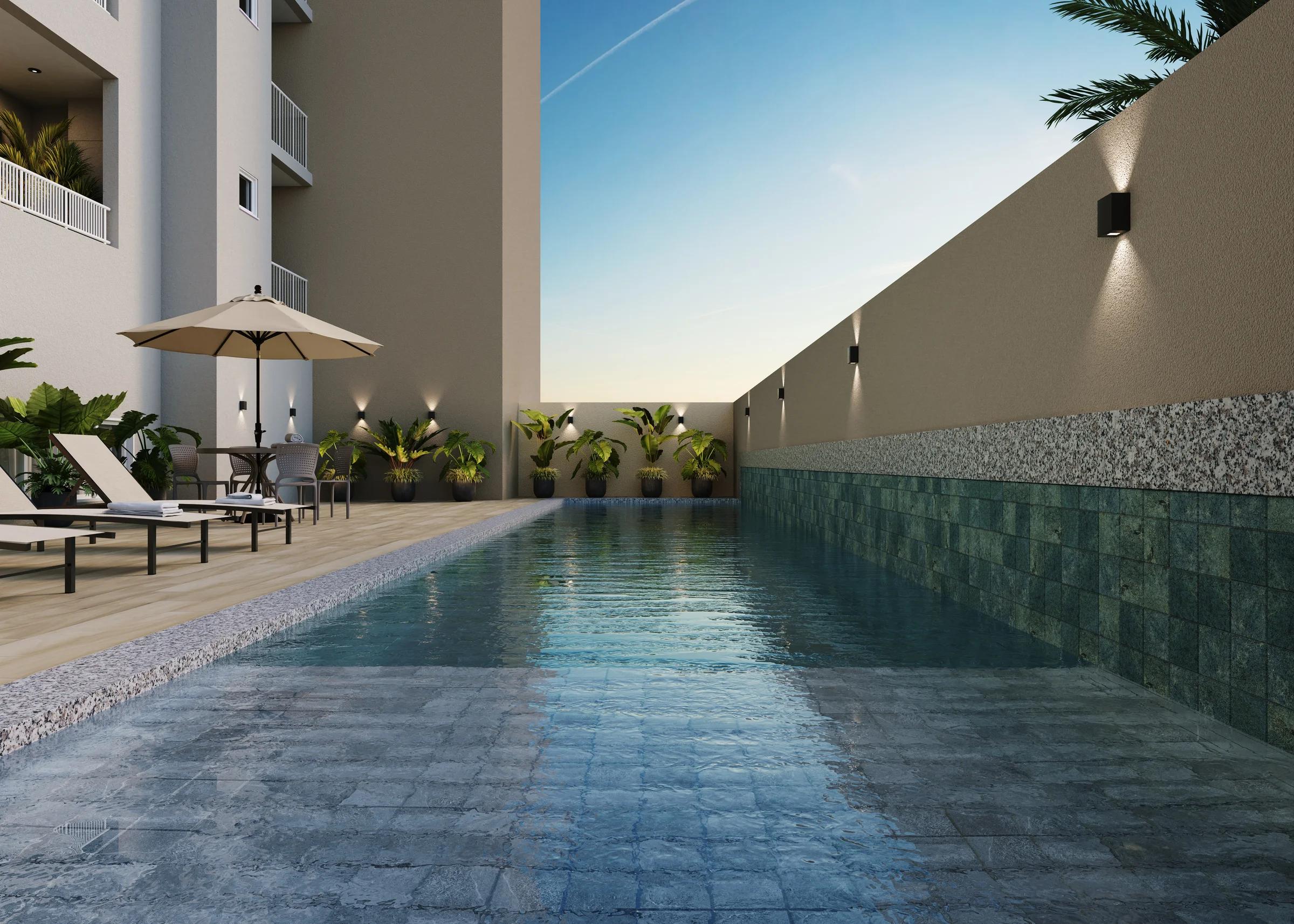 Piscina com raia de natação com revestimento em pastilhas verdes e deck com espreguiçadeiras