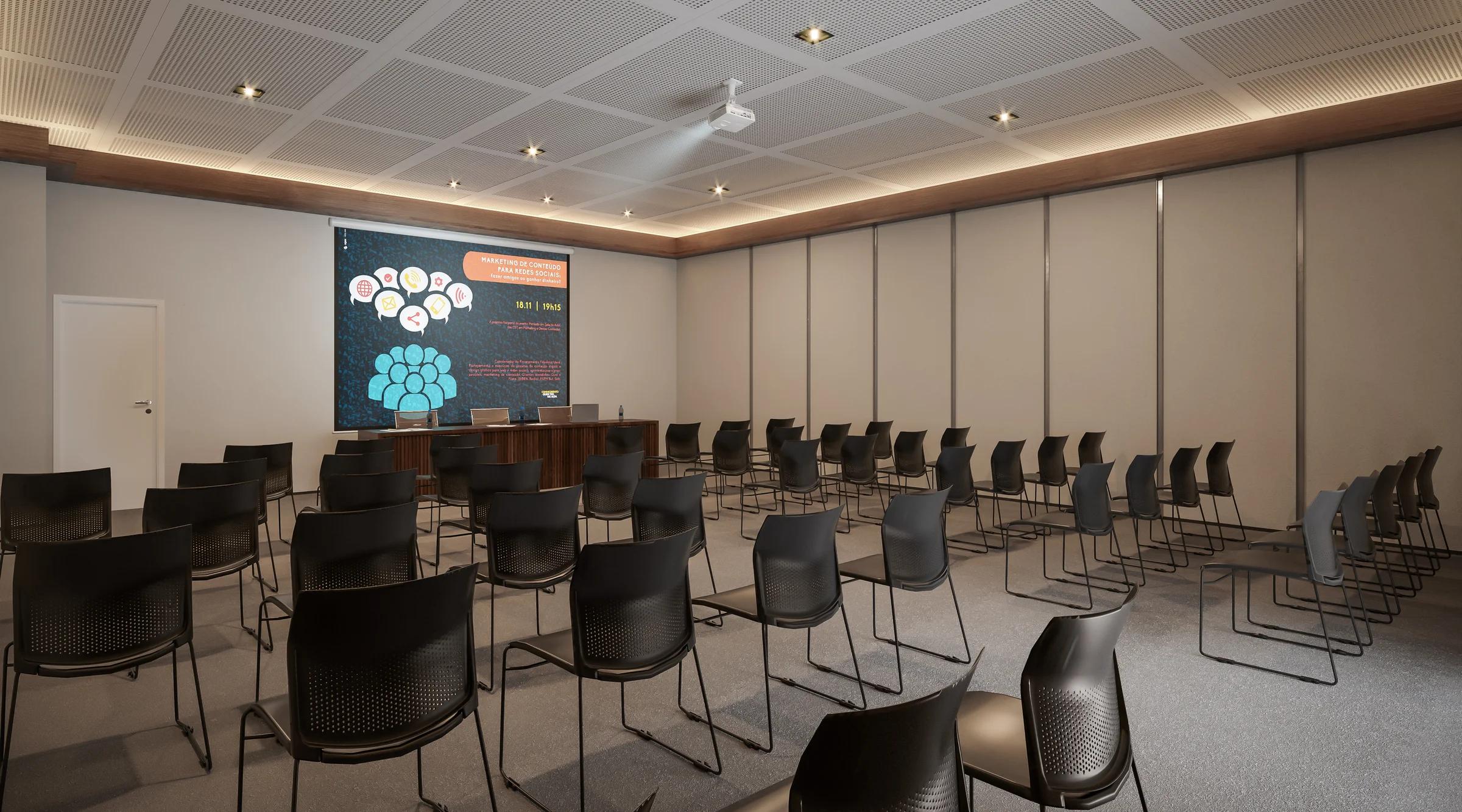Auditório corporativo com tela de projeção e assentos em disposição para palestras.