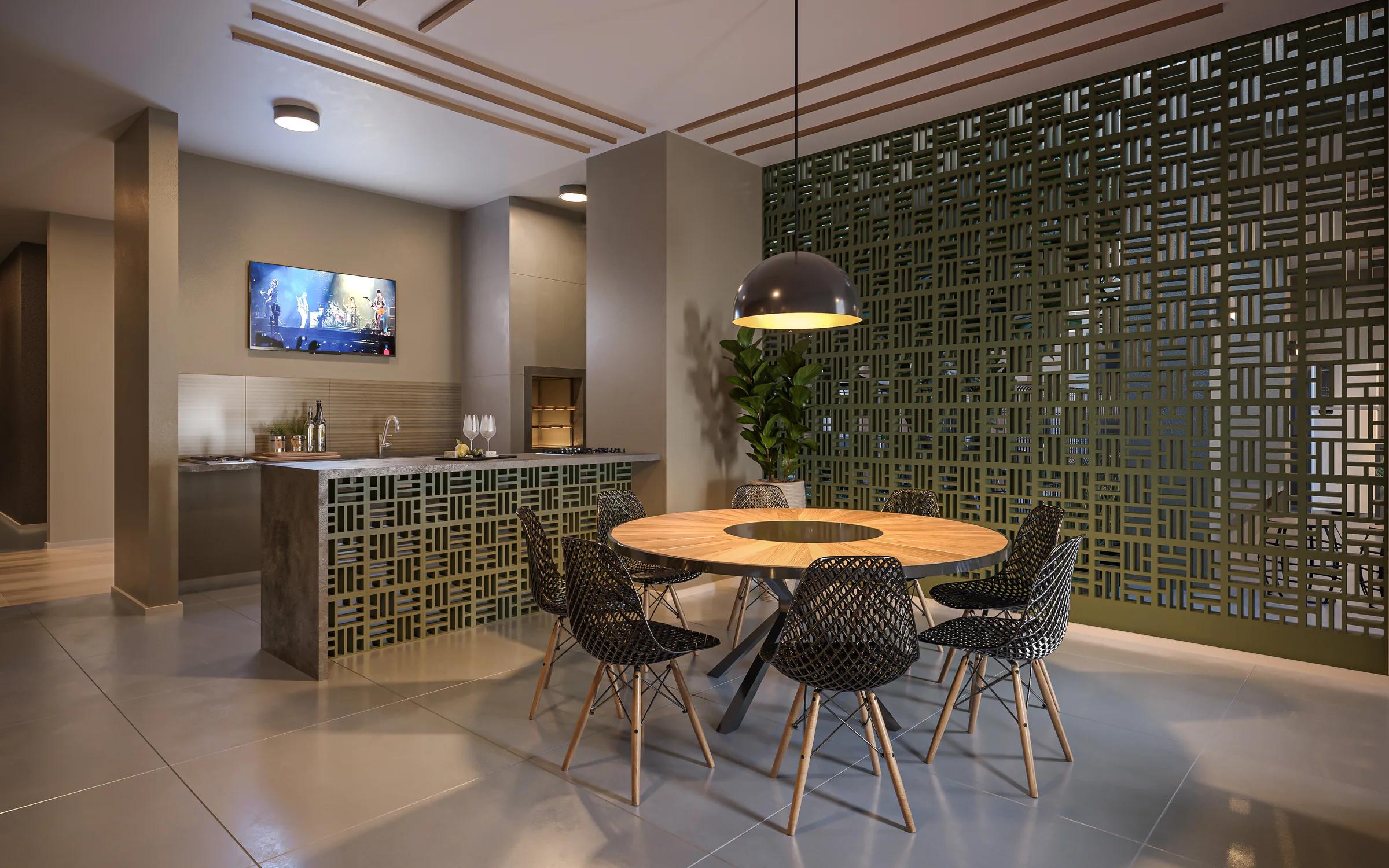 Varanda gourmet com mesa redonda de jantar, bancada de apoio e painel vazado