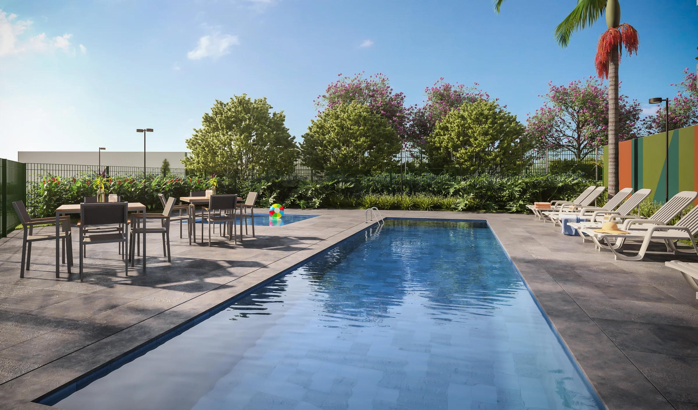 Piscina externa com deck, espreguiçadeiras, mesas e paisagismo integrado
