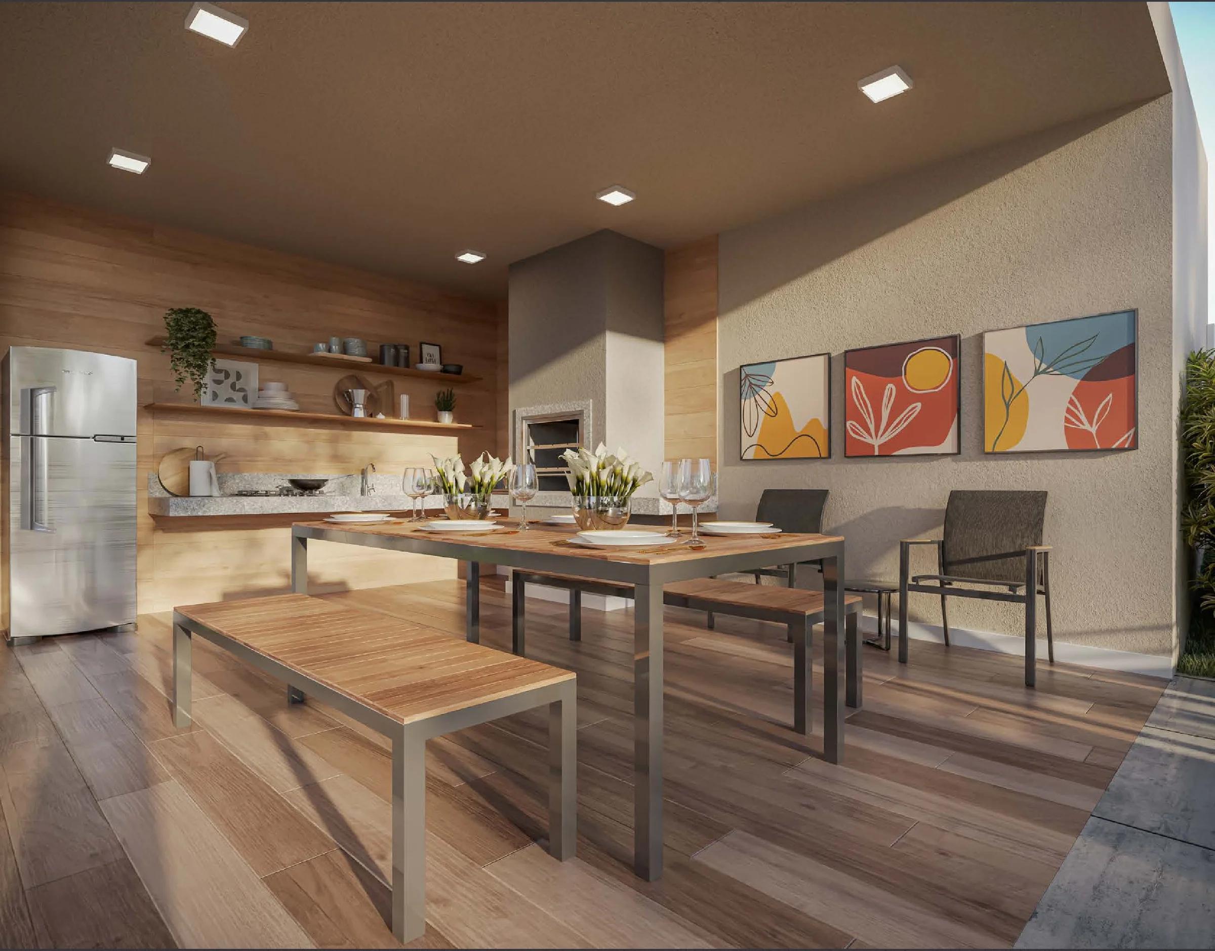 Espaço com churrasqueira gourmet, bancada de apoio, refrigerador e mesa com bancos de madeira