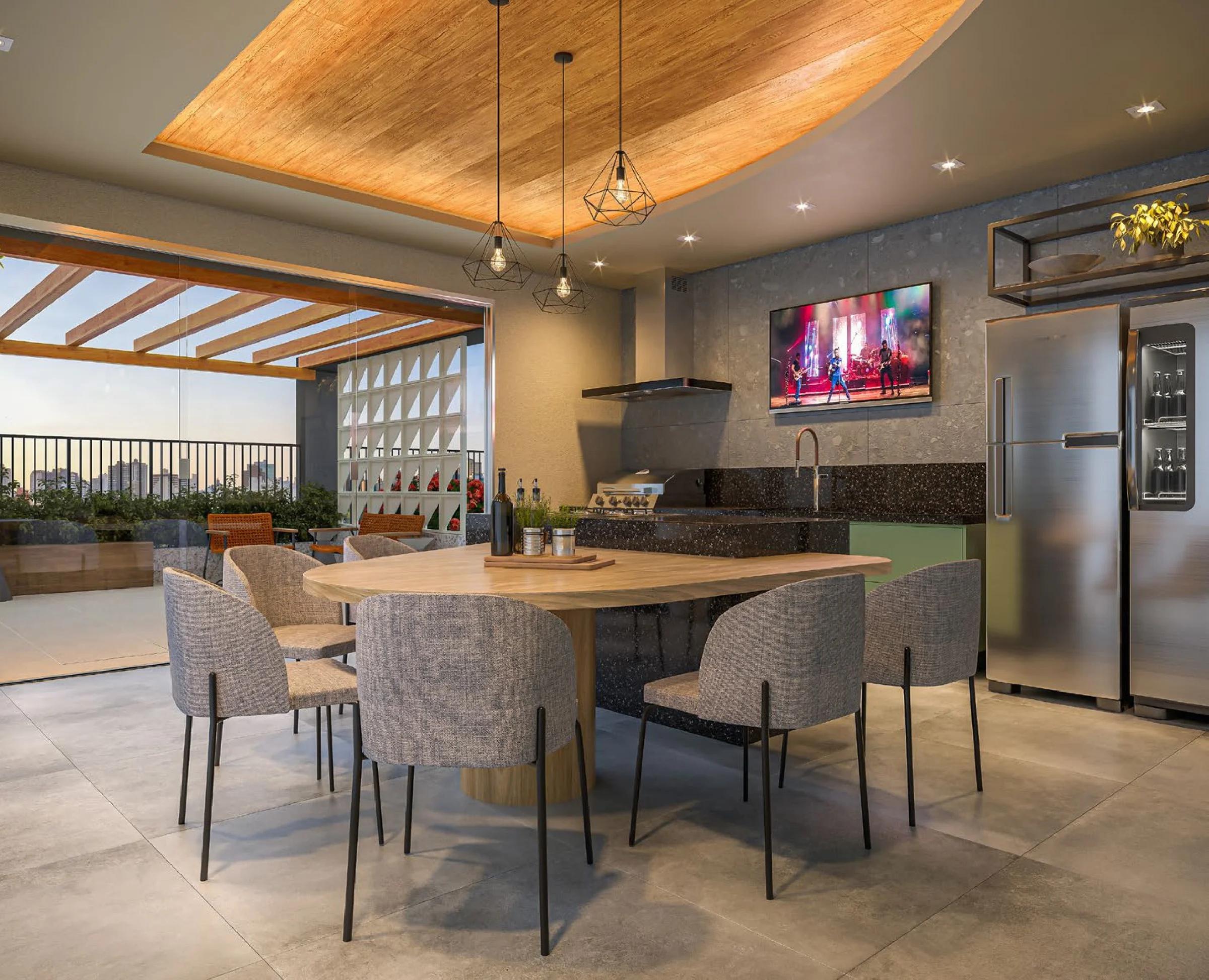 Espaço gourmet interno com churrasqueira, refrigerador e mesa integrada à bancada