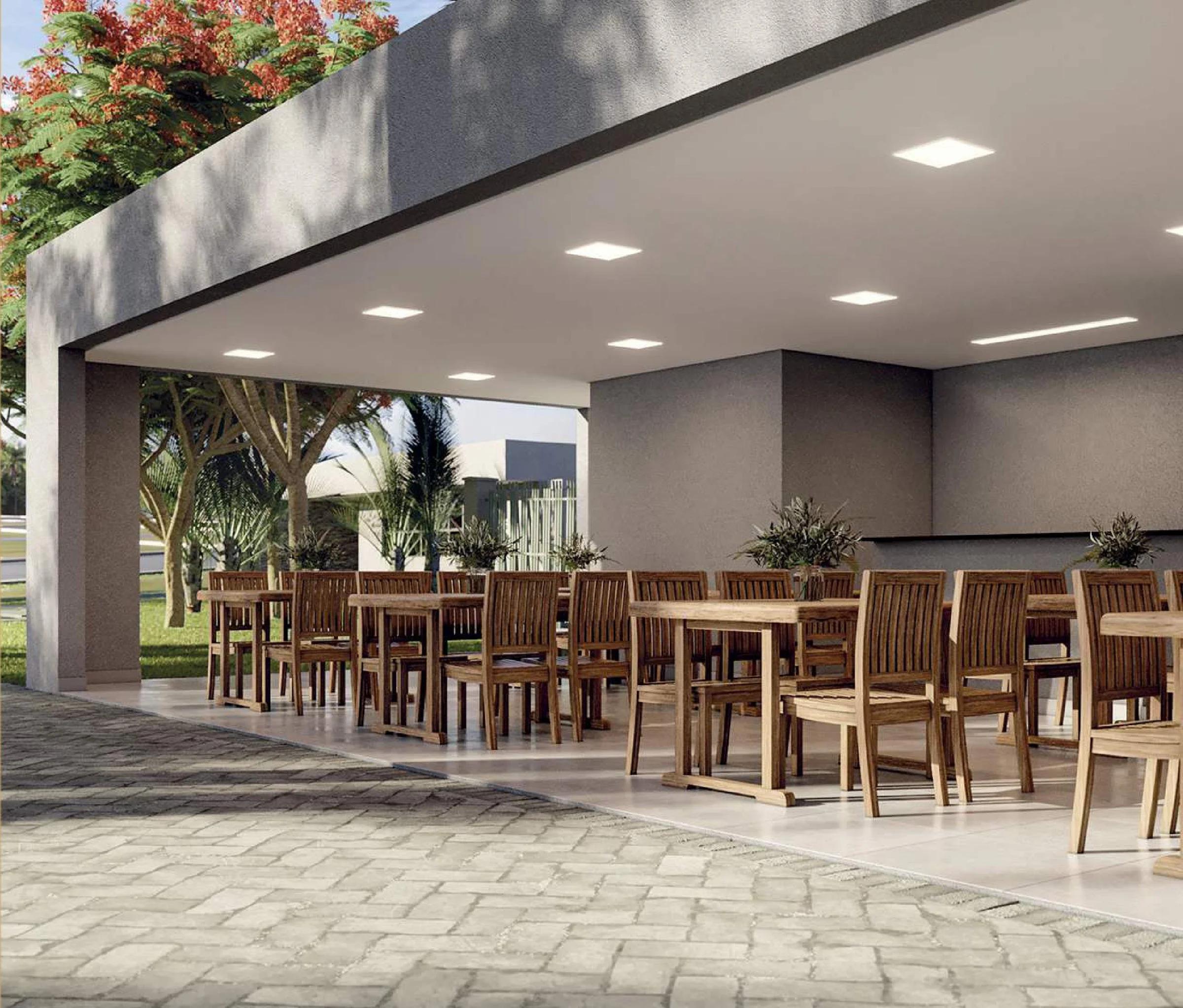 Espaço gourmet e varanda de convivência coberta com mesas e cadeiras de madeira