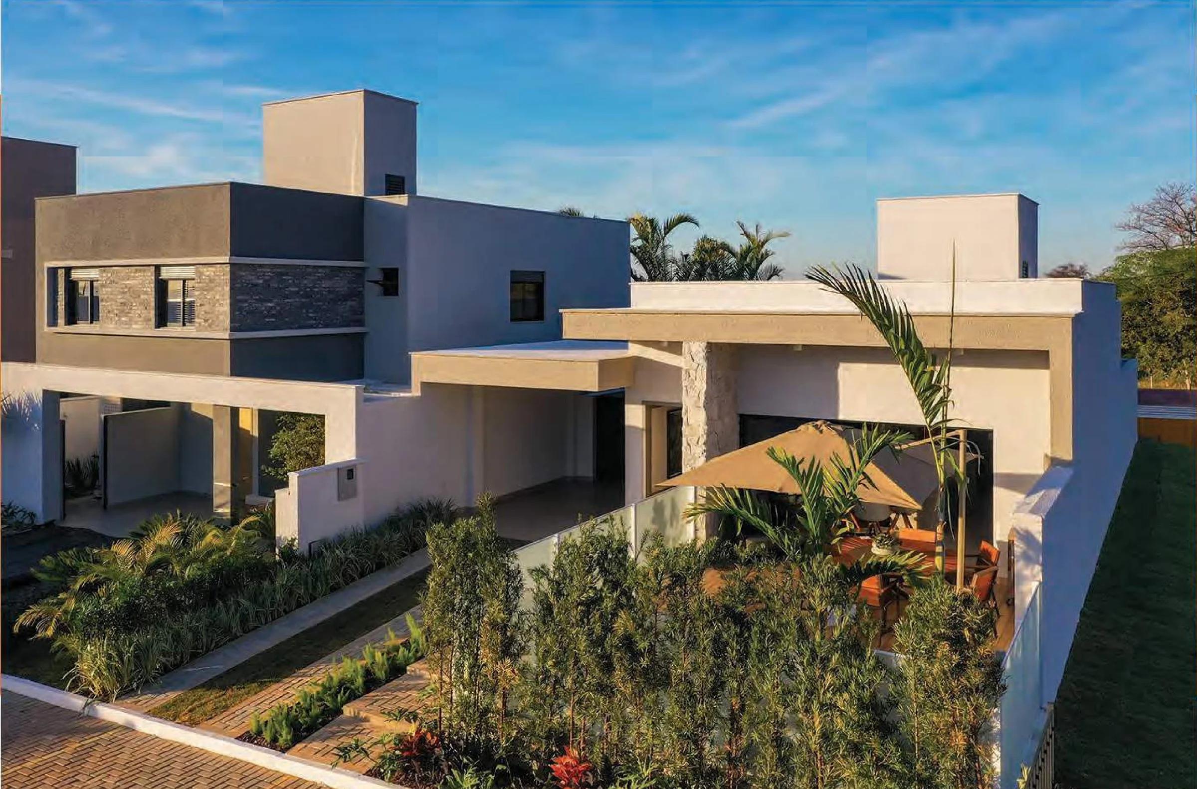 Fachada externa de casas contemporâneas no condomínio com jardim frontal