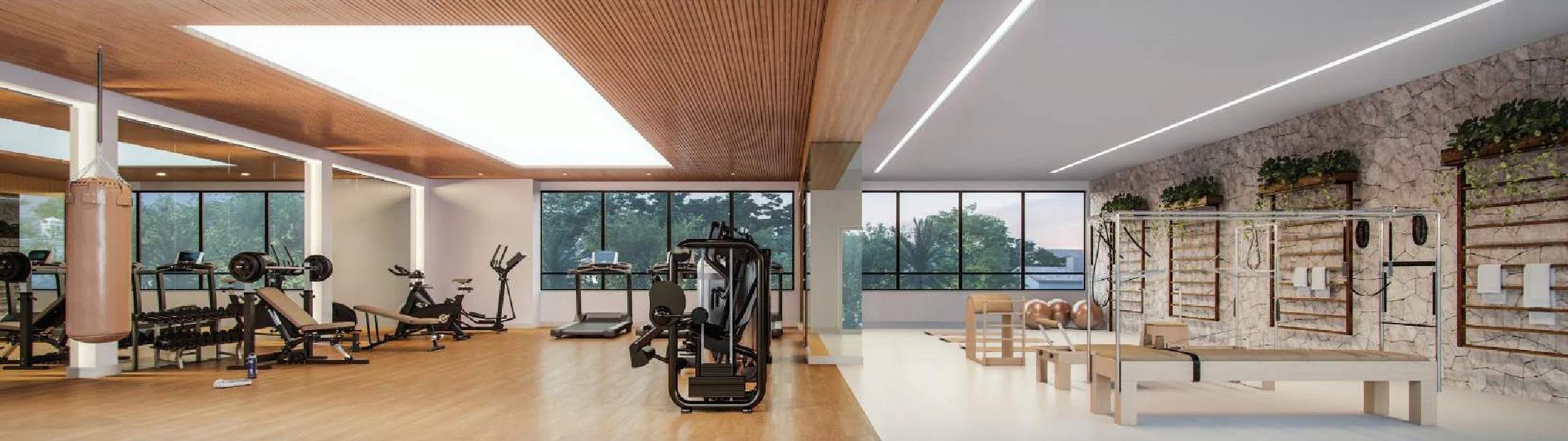 Academia com equipamentos de musculação, esteiras e espaço integrado para pilates