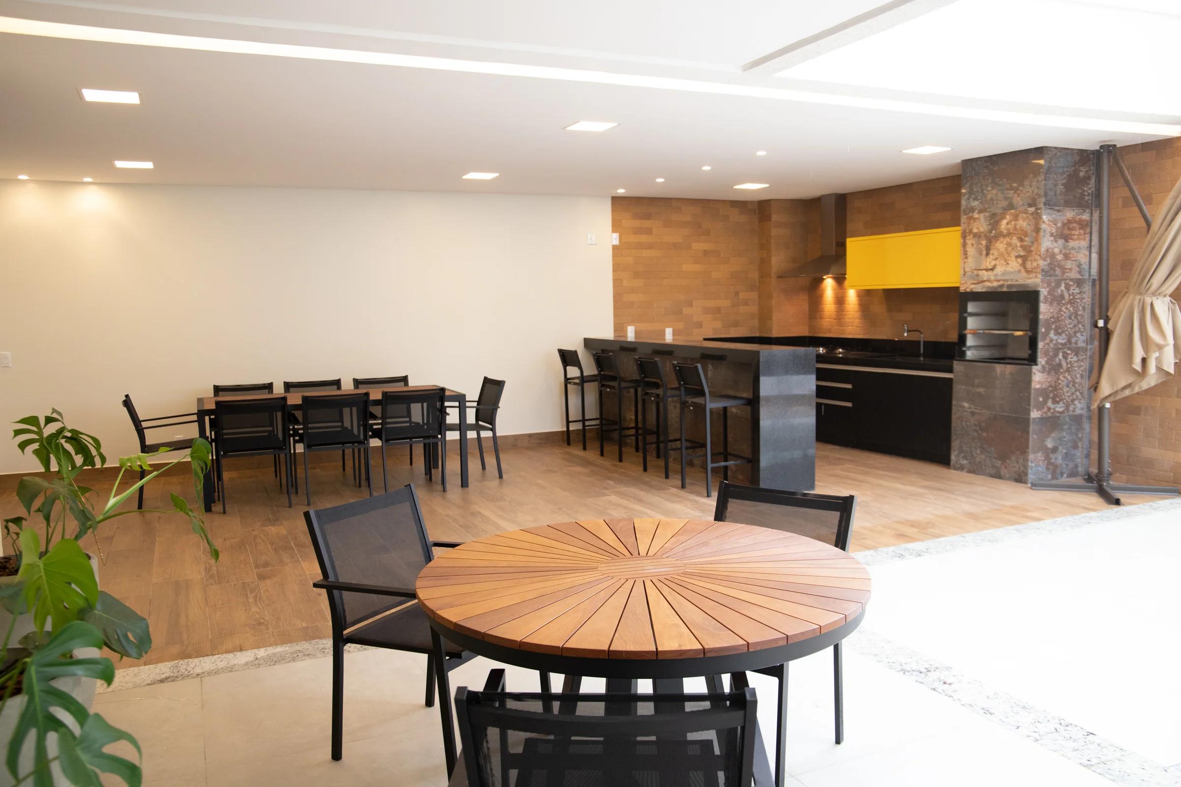 Espaço gourmet com churrasqueiras e mesa de refeições
