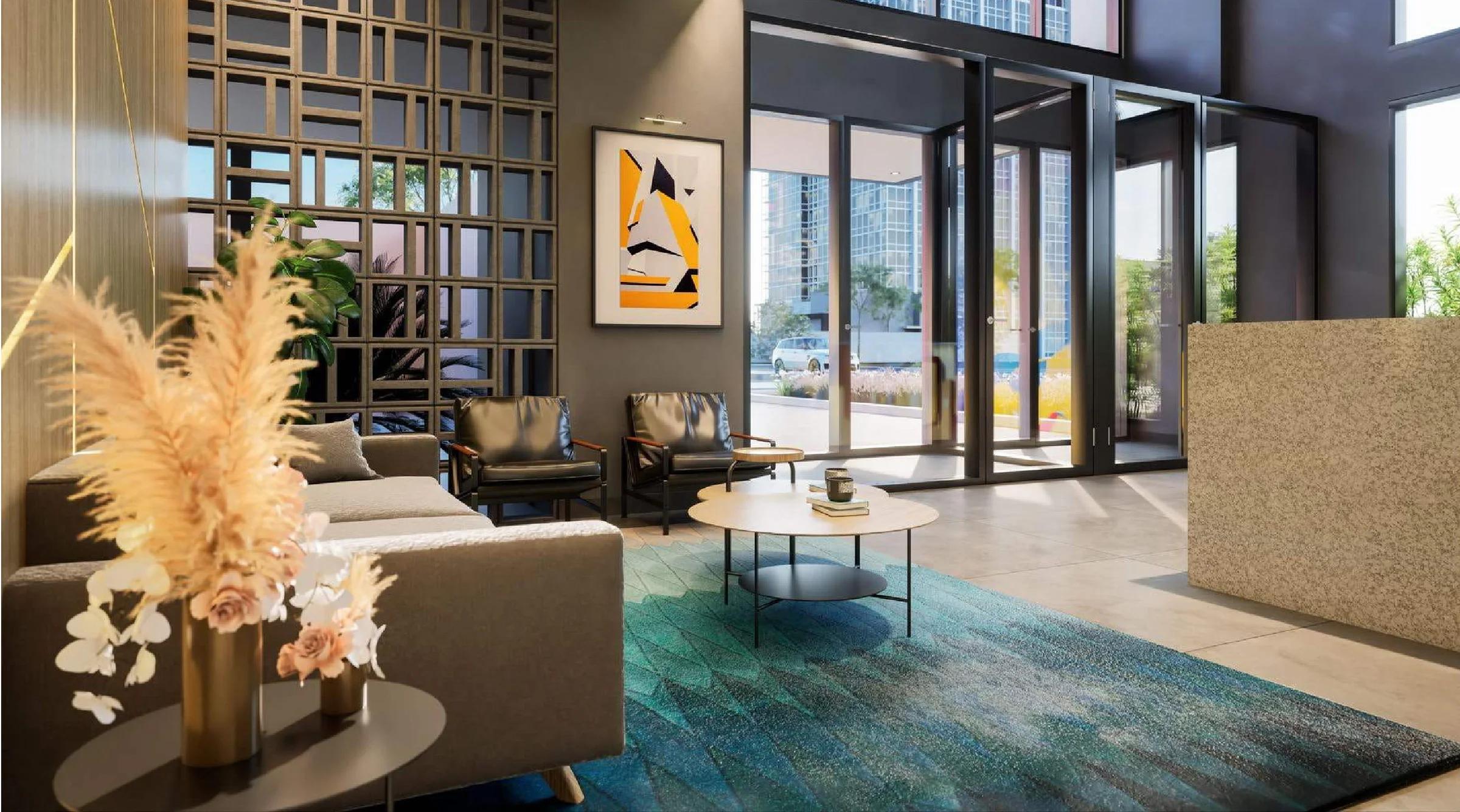 Lounge de espera no lobby com poltronas, sofá e vista para o exterior