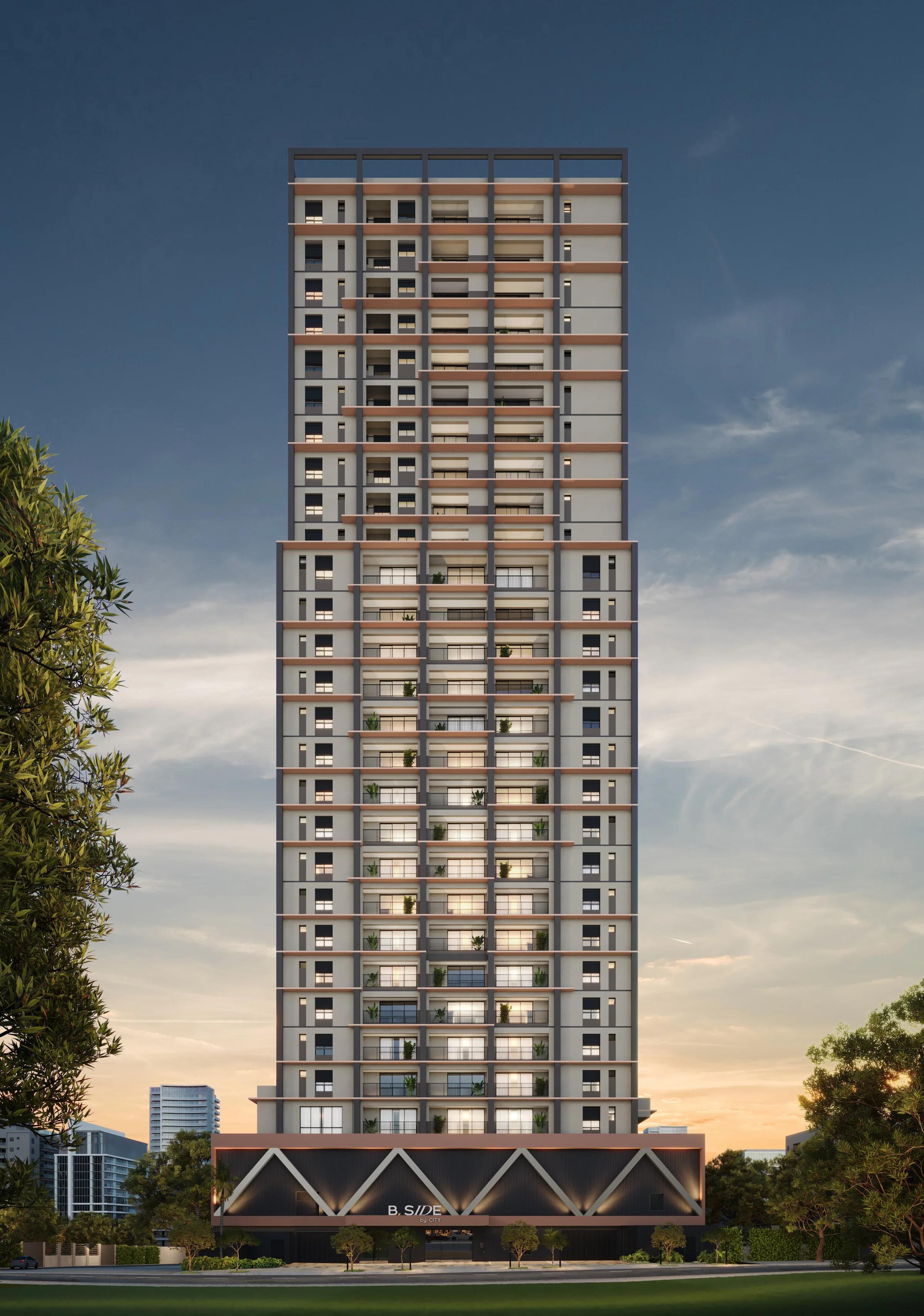 Fachada frontal da torre residencial com detalhes arquitetônicos e base iluminada ao entardecer