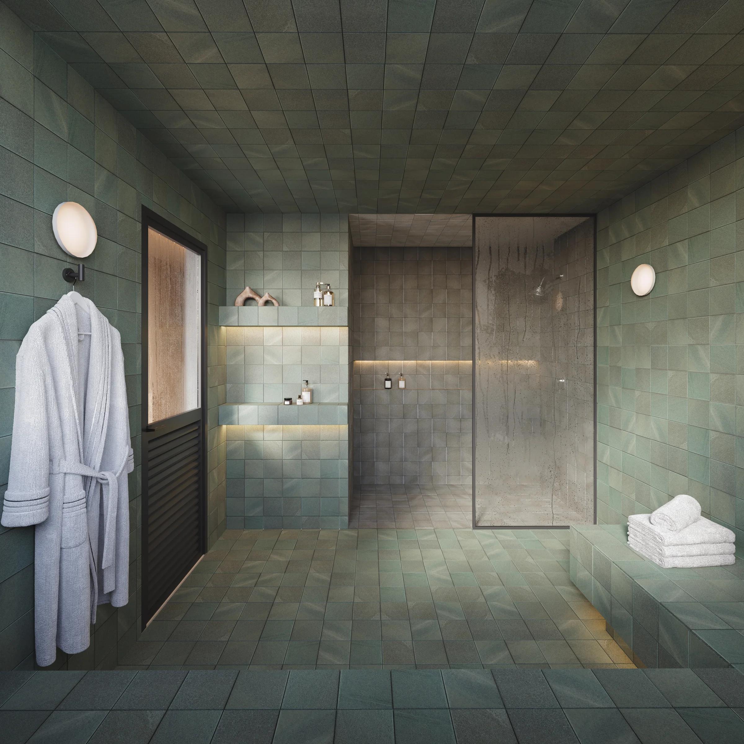 Sauna e área de relaxamento revestida com azulejos verdes e chuveiro envidraçado