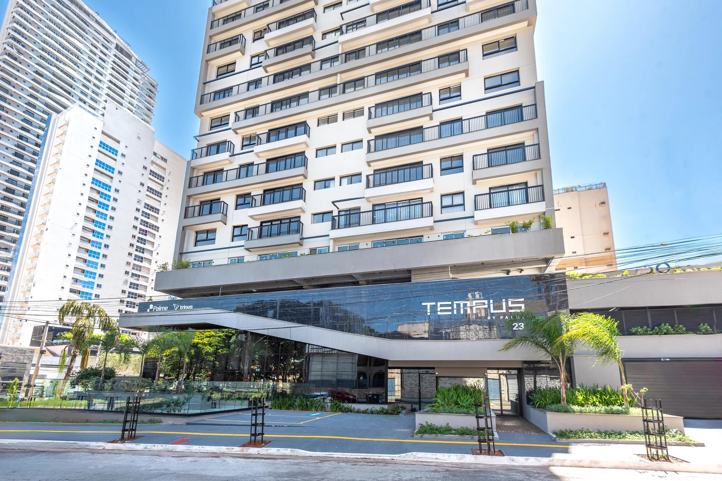 Foto diurna da fachada e da entrada do edifício.