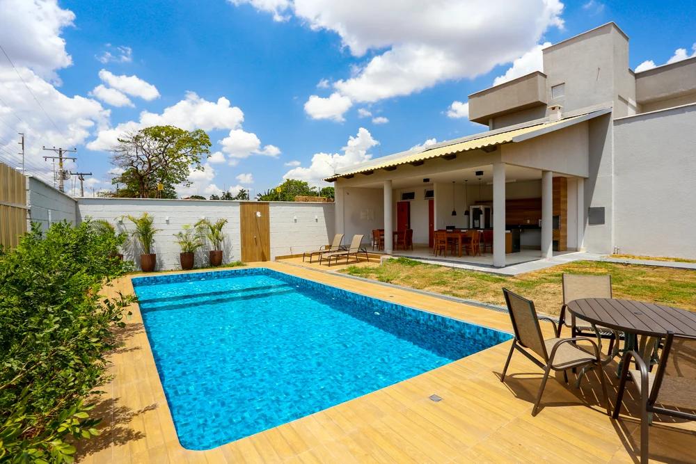 Foto da piscina e da área externa de um sobrado.