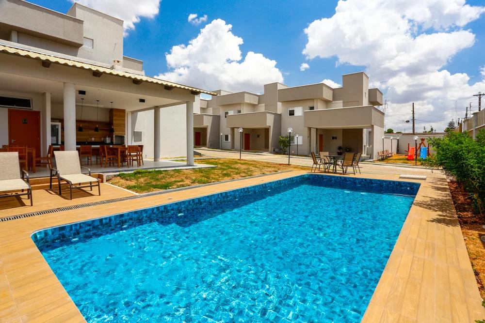Foto da piscina e do espaço de convivência externo.