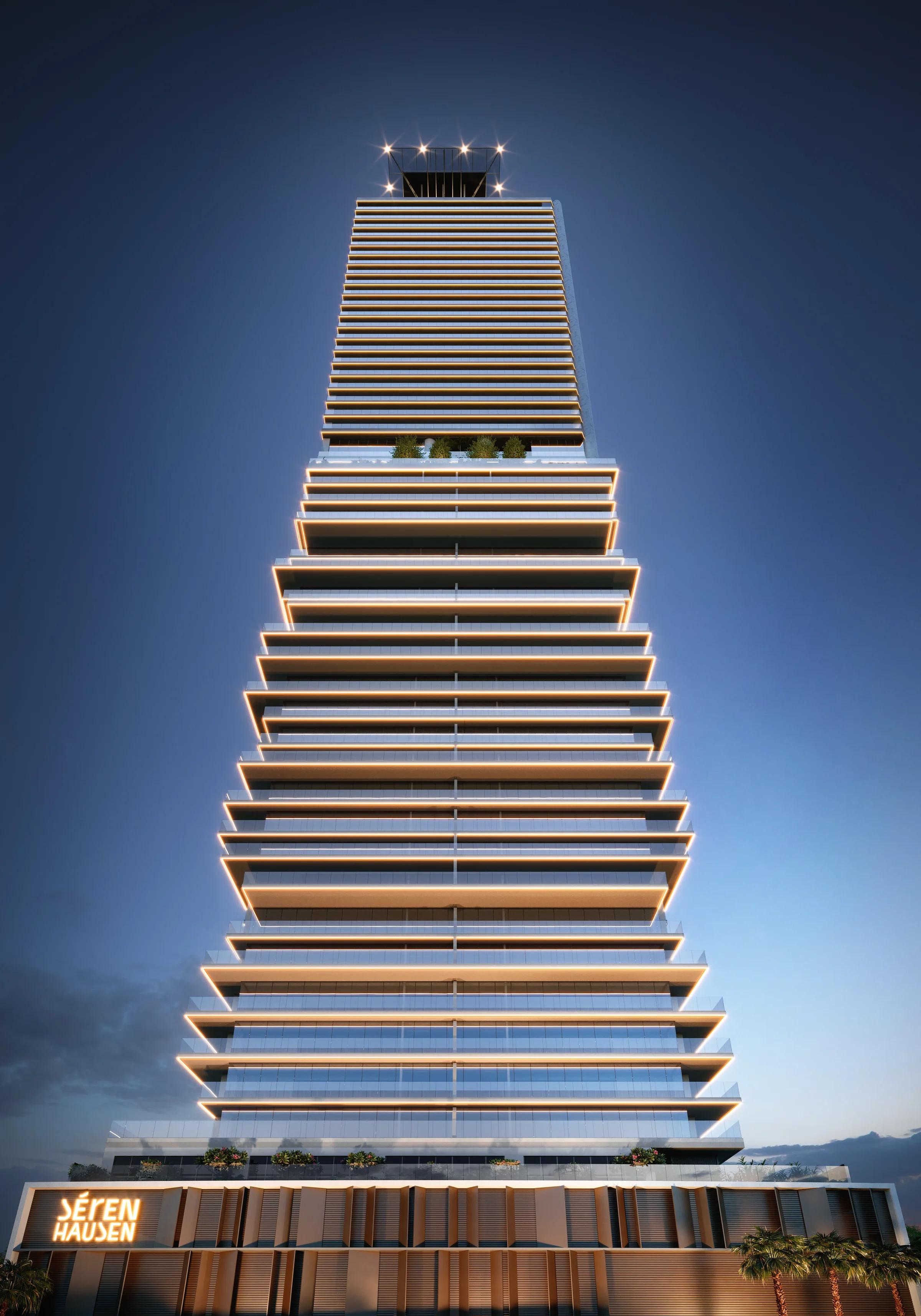 Vista frontal da torre iluminada ao anoitecer com detalhes dos terraços em balanço