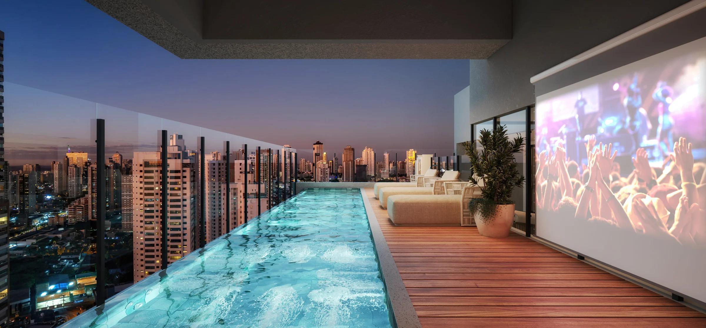 Deck do rooftop com piscina e telão de cinema ao ar livre ao entardecer