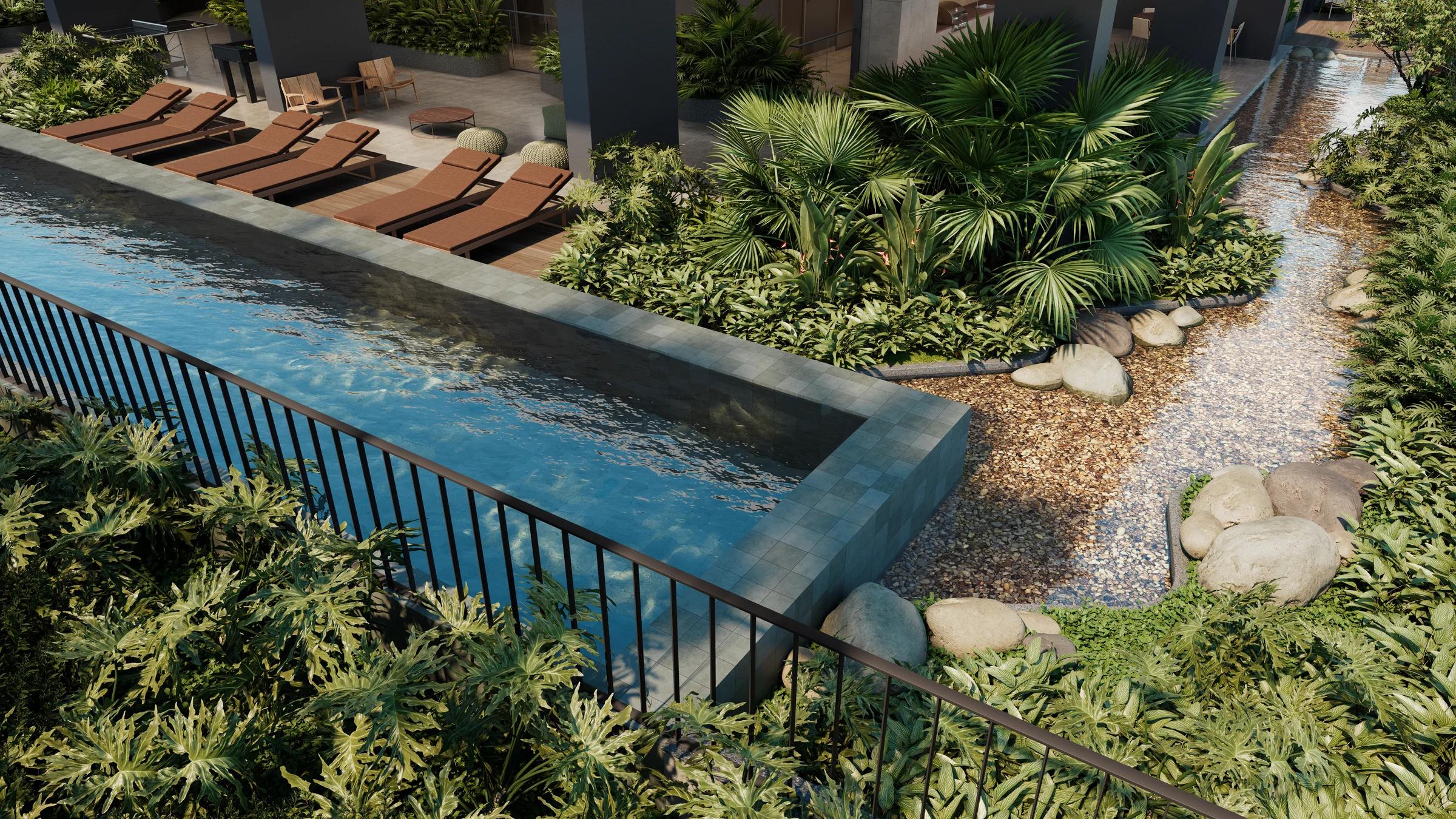 Piscina com raia, espreguiçadeiras e espelho d'água com pedras naturais e vegetação tropical
