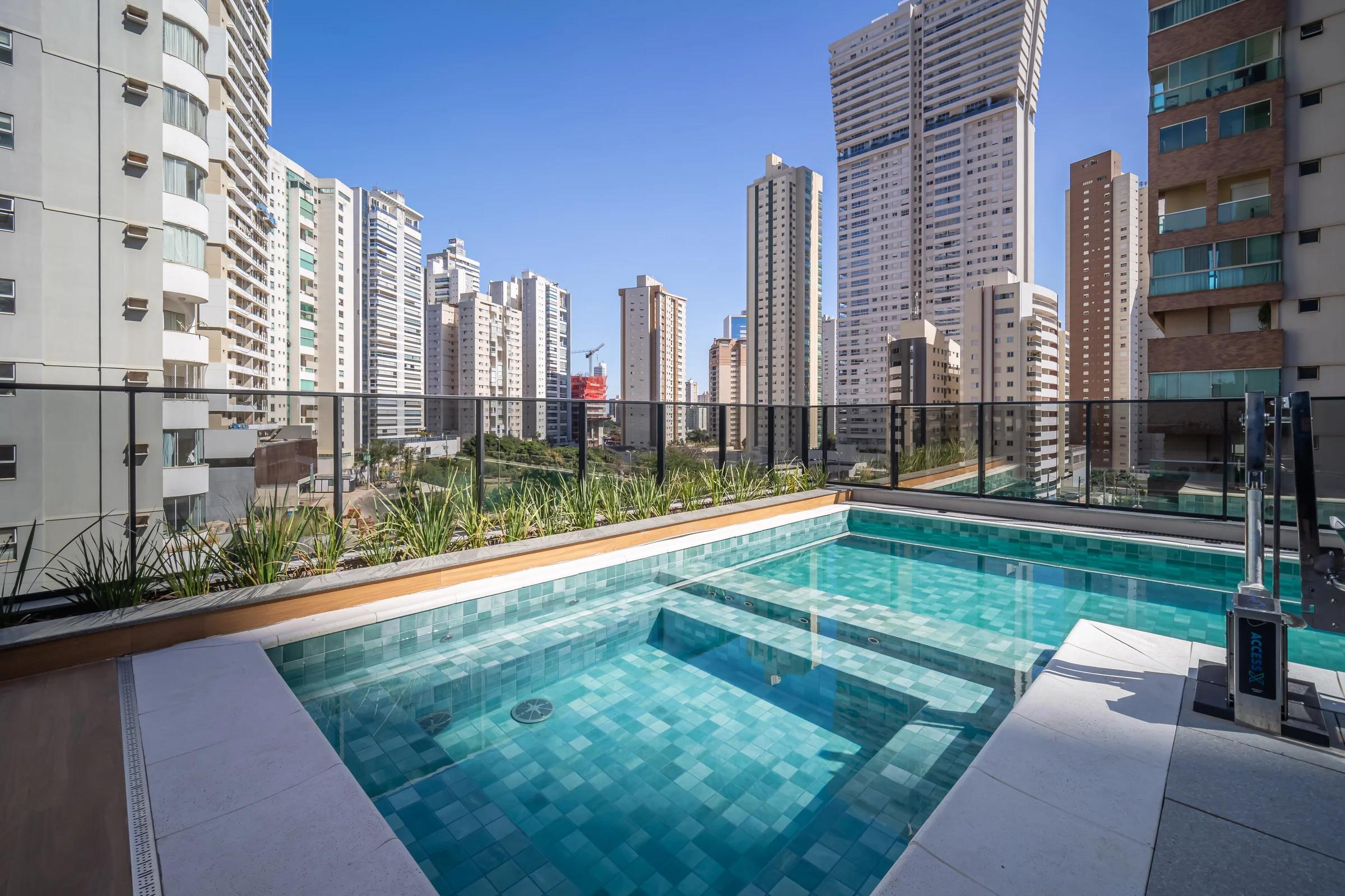 Foto da piscina com deck e edifícios ao redor