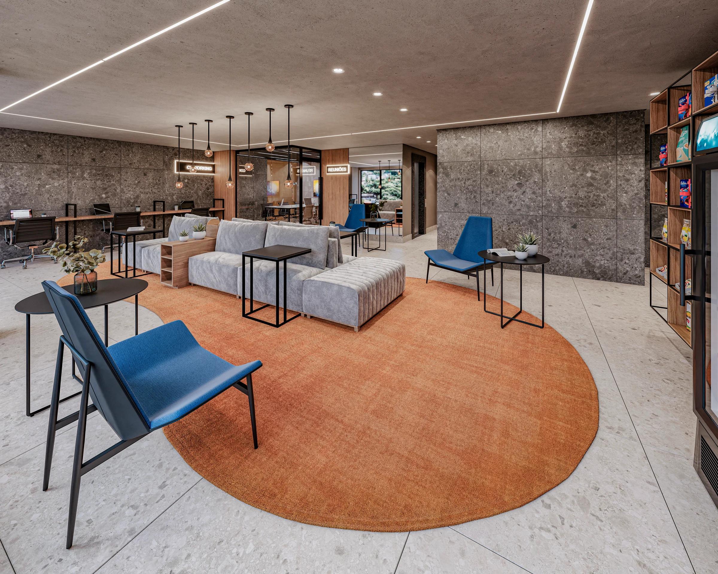 Lobby e espaço coworking com poltronas azuis, sofás modulares e tapete redondo