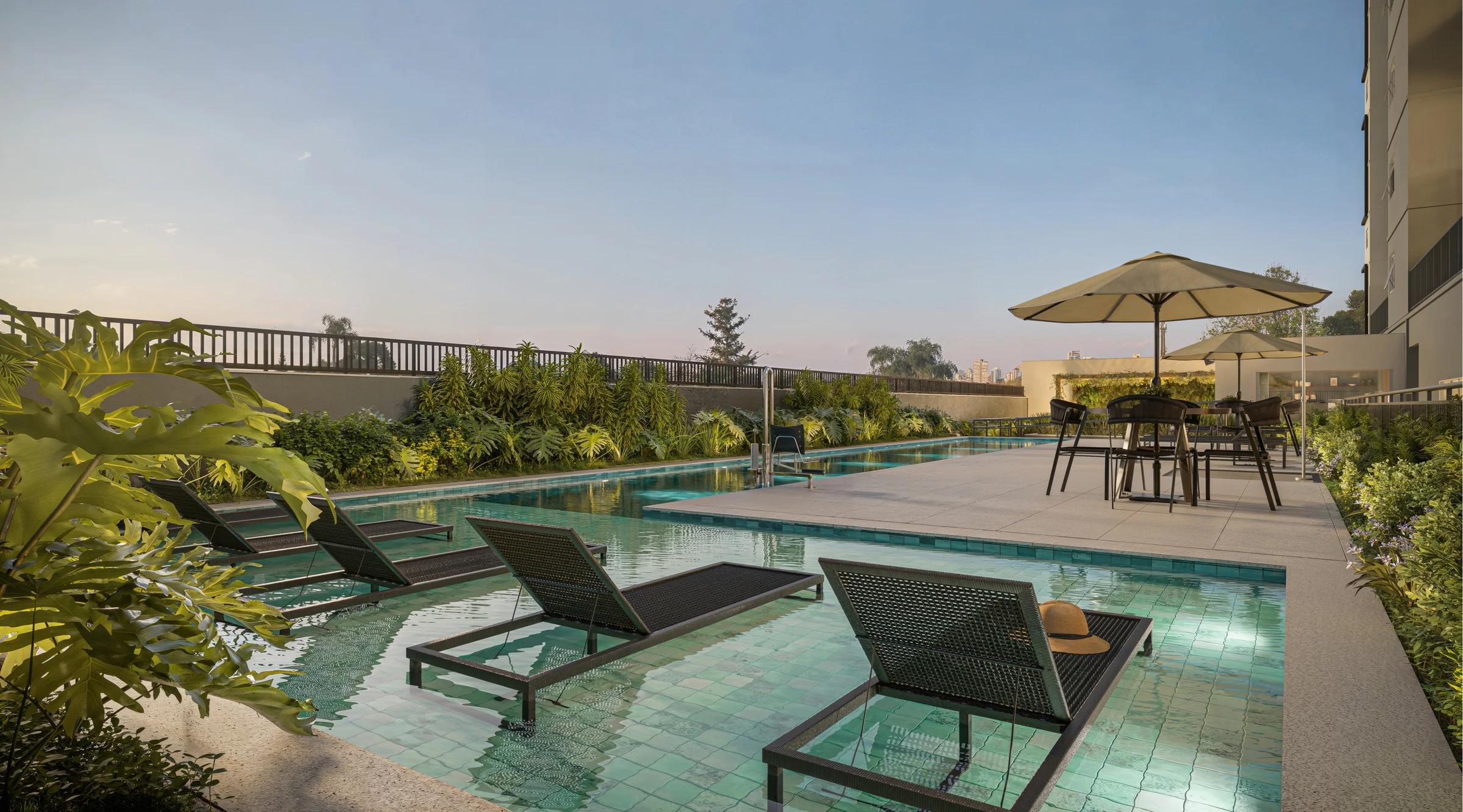 Piscina com deck molhado e espreguiçadeiras dentro da água