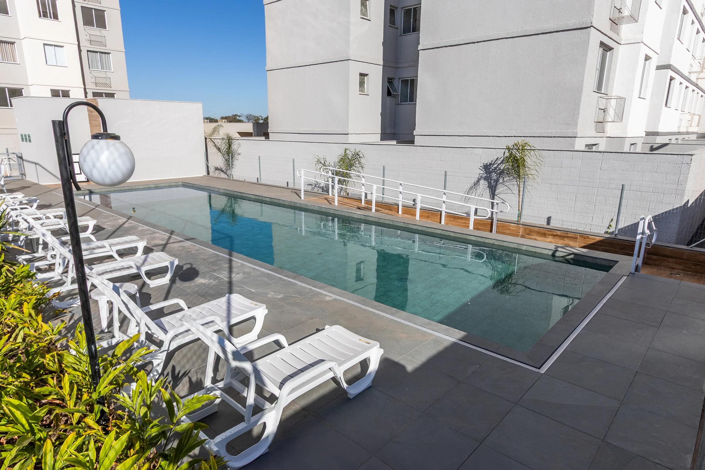 Perspectiva artística da piscina adulto com raia, deck molhado e espreguiçadeiras
