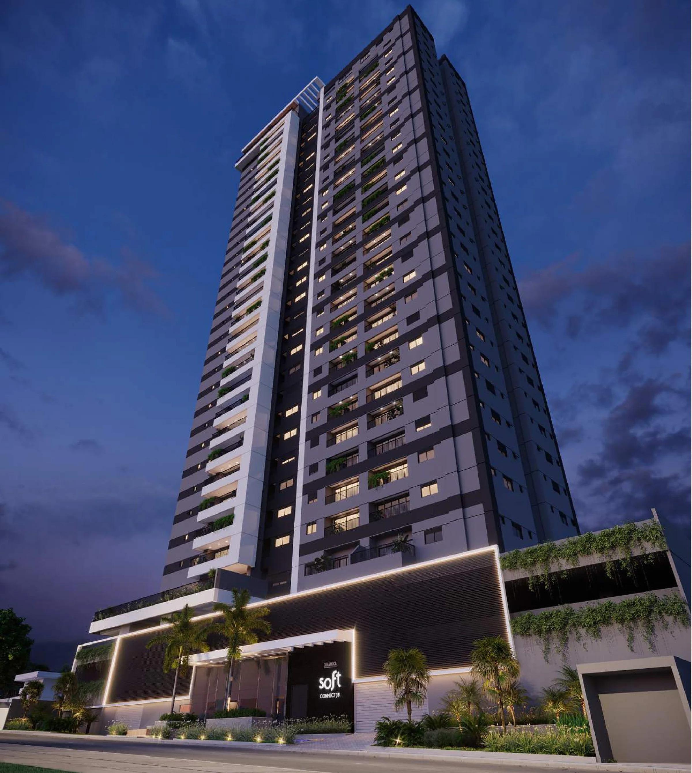Fachada da torre residencial em perspectiva vertical no início da noite com iluminação na base e paisagismo