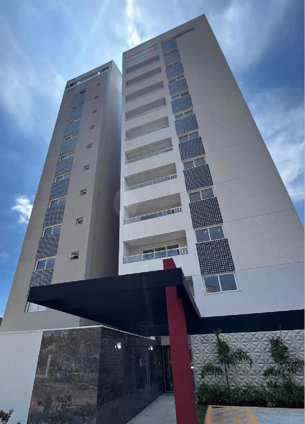 Fachada externa do edifício com detalhes em revestimento escuro e pórtico de entrada vermelho