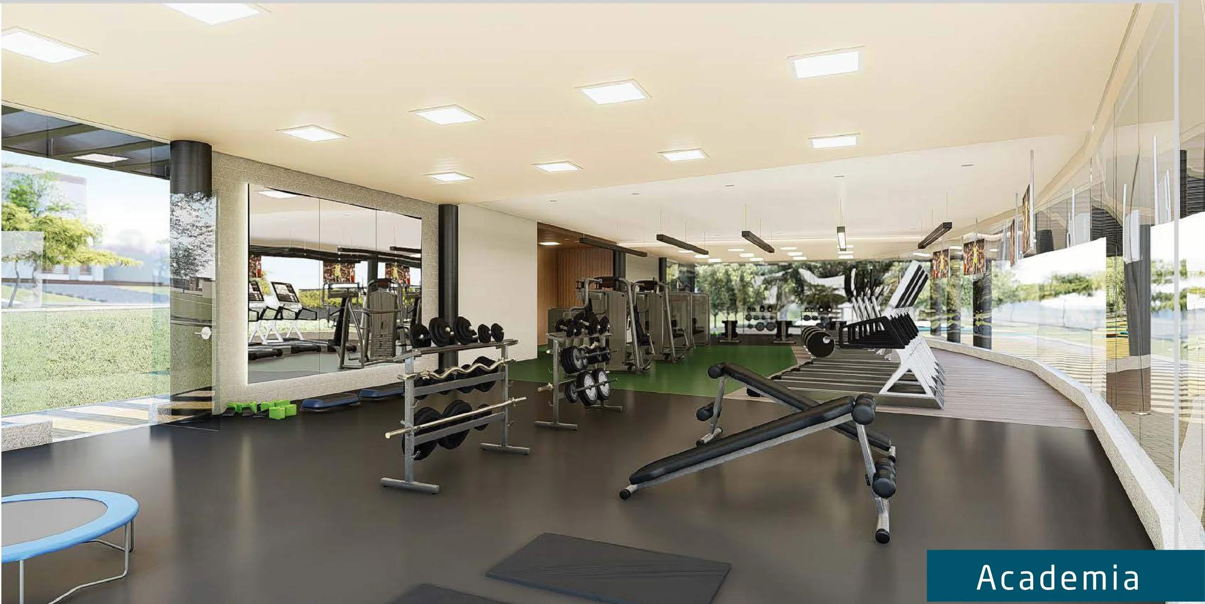 Interior da academia equipada com esteiras, pesos e vista para o jardim