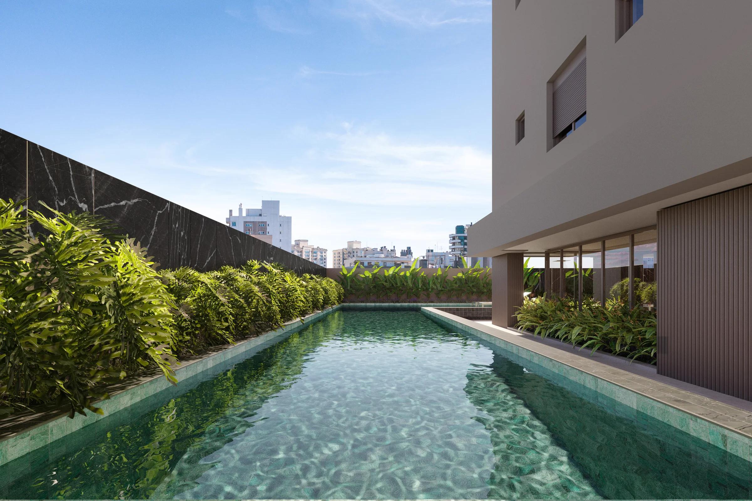 Piscina com raia para natação cercada por jardineiras com vegetação tropical